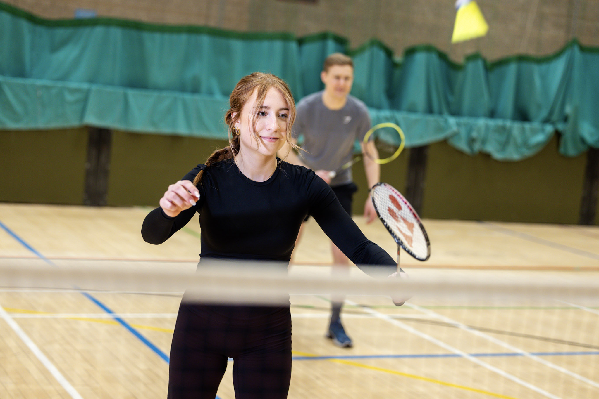 Woman playing badminton in the sports hall at Inverness Leisure