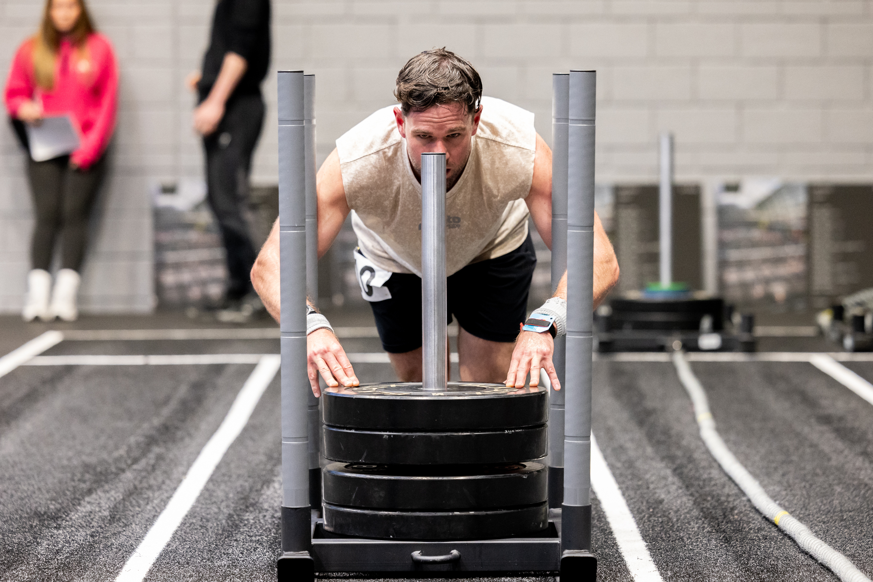 Man pushing a weighted sled along the track, HYROX studio Inverness Leisure