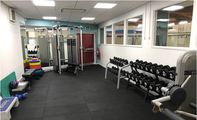 Gym area featuring hand weights and a weights machine