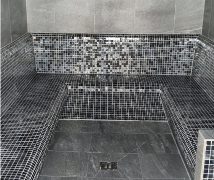 Steam room featuring tiled bench seats and flooring.