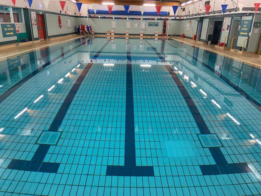 Swimming pool with marked lanes and flags hanging from the ceiling