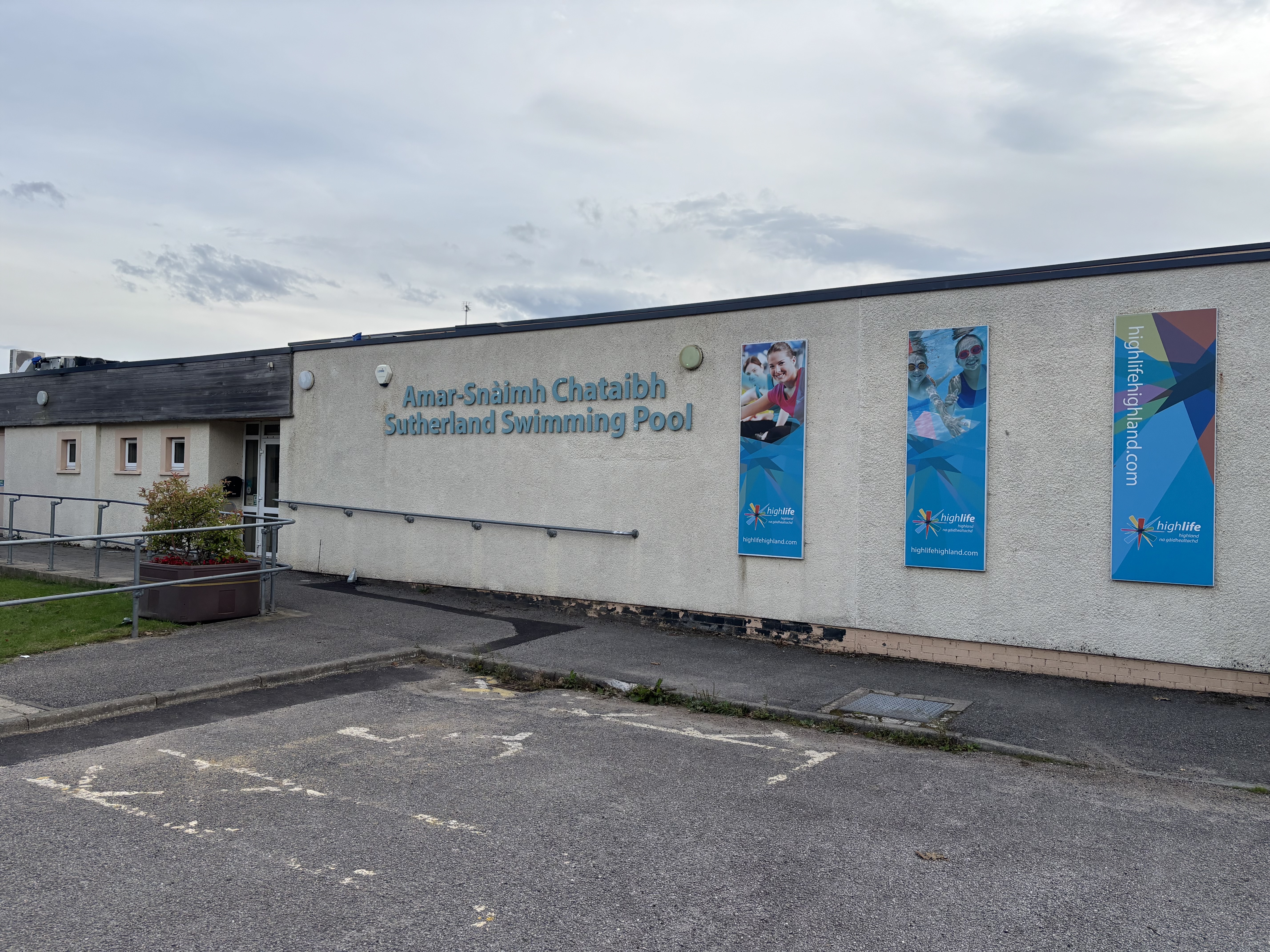 Single-storey building with ramp to main entrance and car park spaces in front.