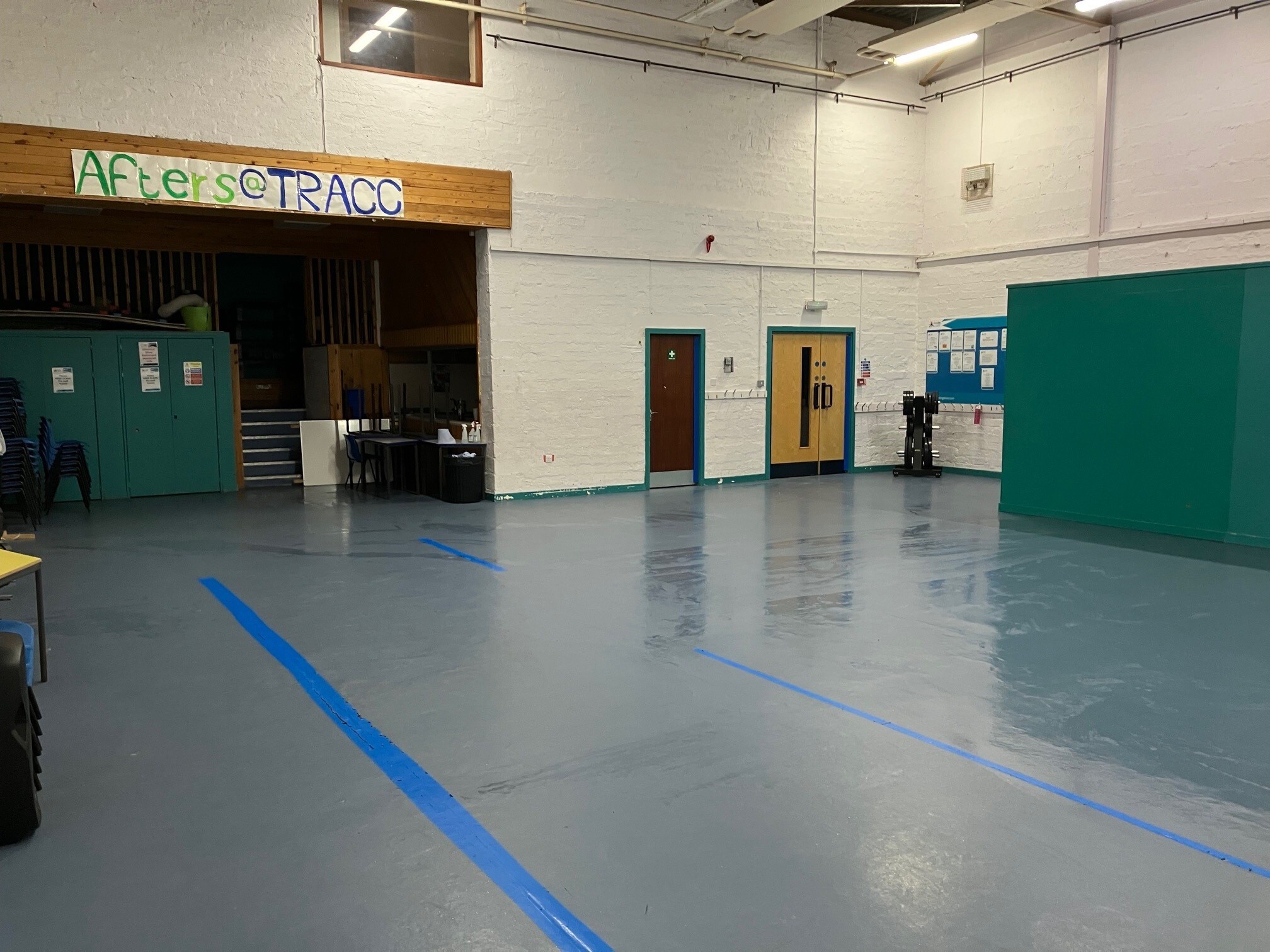 Spacious hall with hard flooring and light coloured walls.