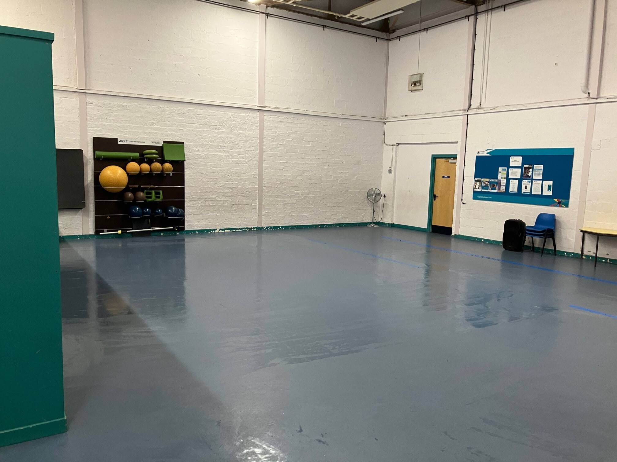 Spacious hall with hard flooring and light coloured walls.