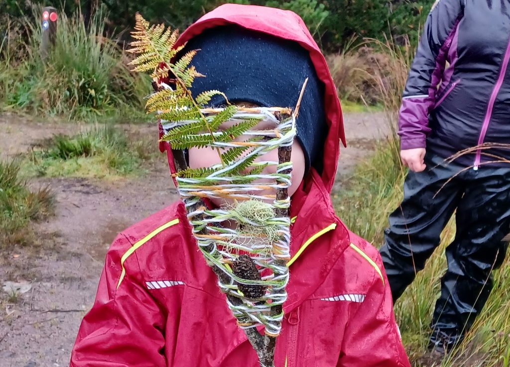 Photo of child enjoying the end product of ‘10 things to do with a stick’ event in Laide earlier this year